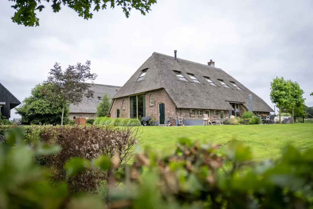 Achterzijde van de verbouwde boerderij met glas in oude staldeuren
