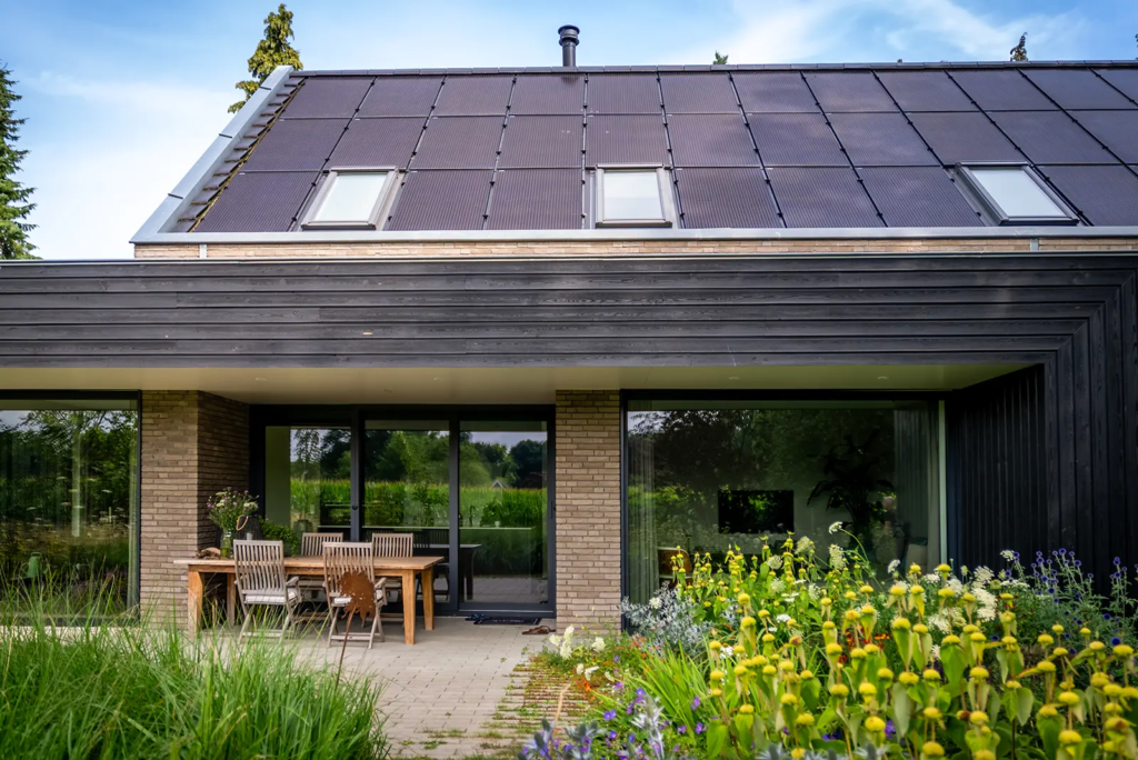 Moderne woning in Gorssel met zwart houten gevel en zonnepanelen, gebouwd door Mensink Bouwbedrijf.