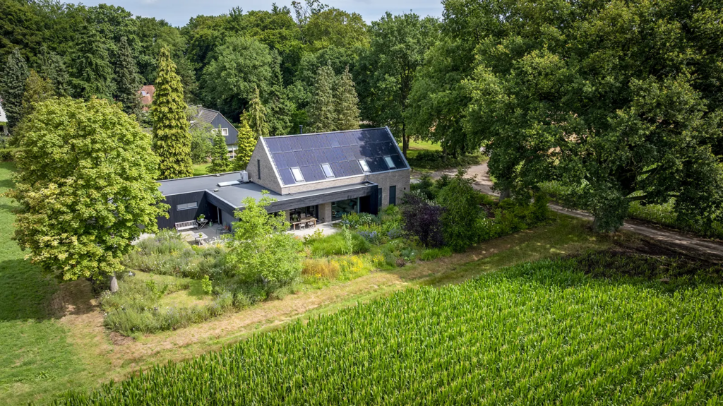 Luchtfoto van woning met zonnepanelen en groene tuin in Gorssel, duurzaam gebouwd door Mensink Bouwbedrijf.