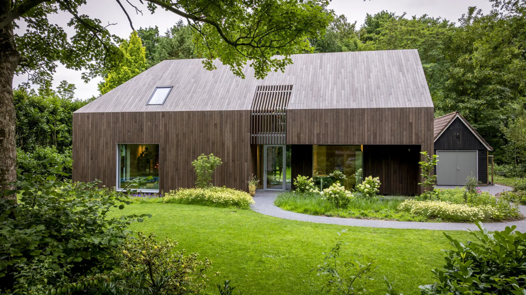 Houten woning in Berkum met natuurlijke uitstraling en tuinpad, vakmanschap van Mensink Bouwbedrijf.