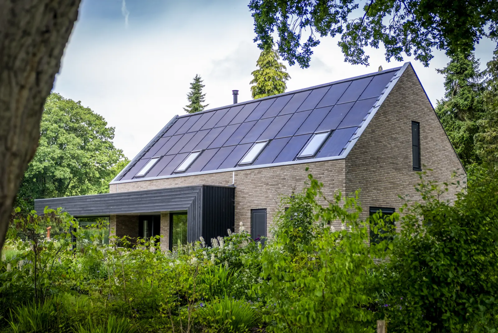 Zijaanzicht van duurzame woning met zonnepanelen en zwarte gevelbekleding in Gorssel.