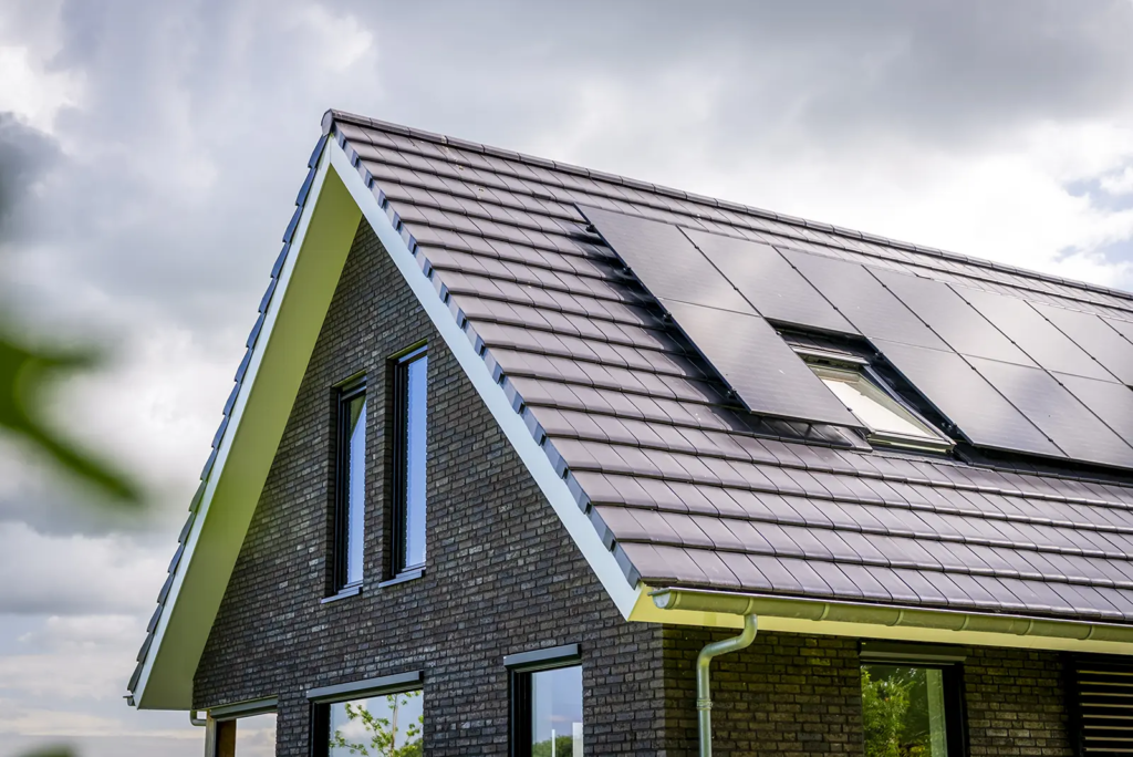 Detail van het dak met zonnepanelen en keramische dakpannen van schuurwoning in Olst.
