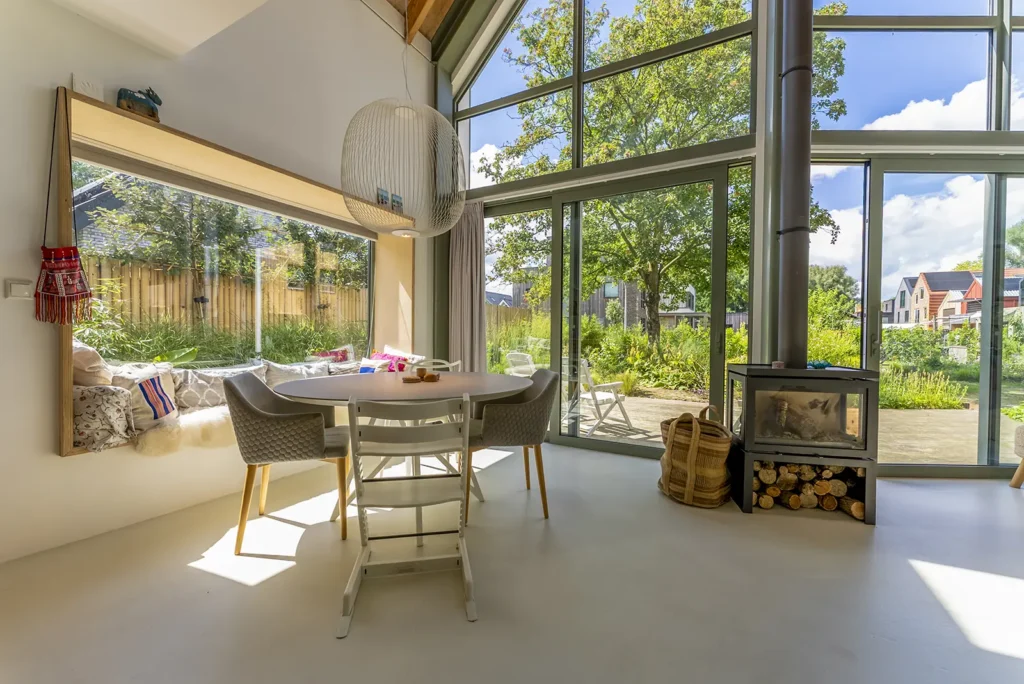 Eethoek met grote raampartijen in een tinyhouse in Deventer, waar binnen en buiten naadloos in elkaar overgaan.