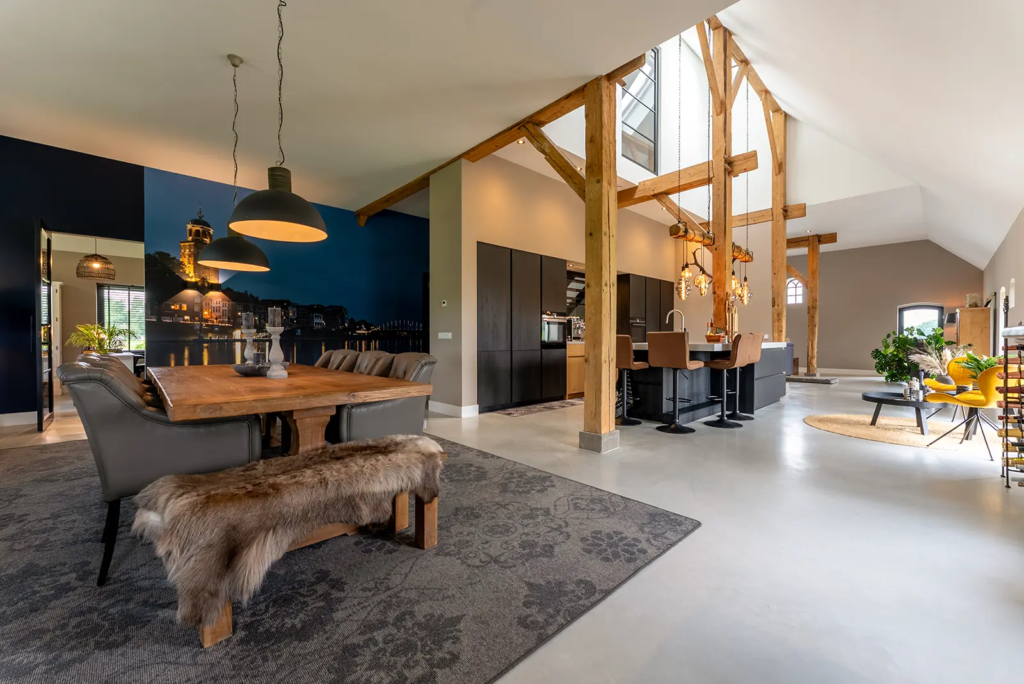 Eetkamer met houten balken en sfeervolle verlichting in woonboerderij in Okkenbroek.