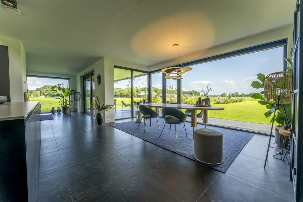 Moderne leefruimte met grote ramen en uitzicht op het Sallandse landschap, gebouwd door Mensink Bouwbedrijf.