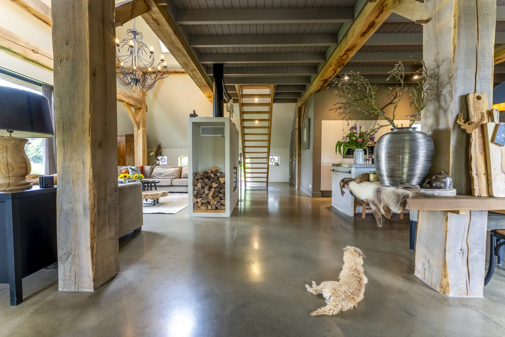 Ruim landelijk interieur met houten spanten en moderne afwerking in gerenoveerde woonboerderij in Okkenbroek.