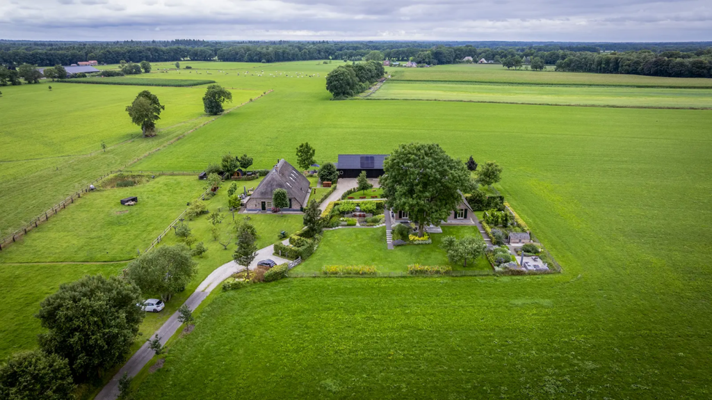 Luchtfoto van erf met woonboerderij en schuur in Okkenbroek, voorbeeld van erftransformatie door Mensink.