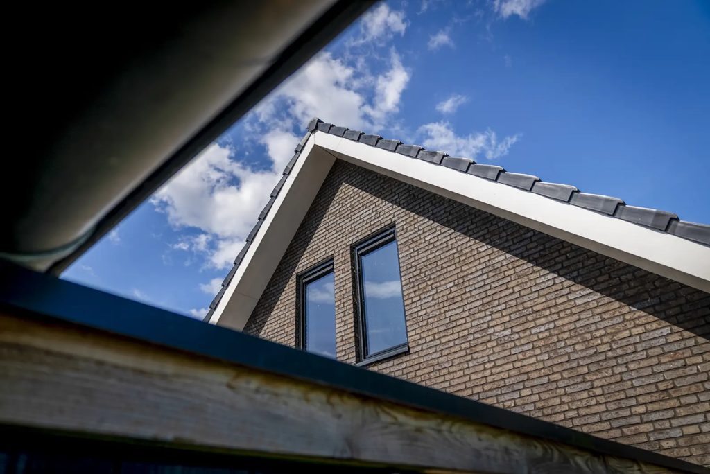 Close-up van topgevel en daklijn met strakke afwerking bij moderne woning in Olst.