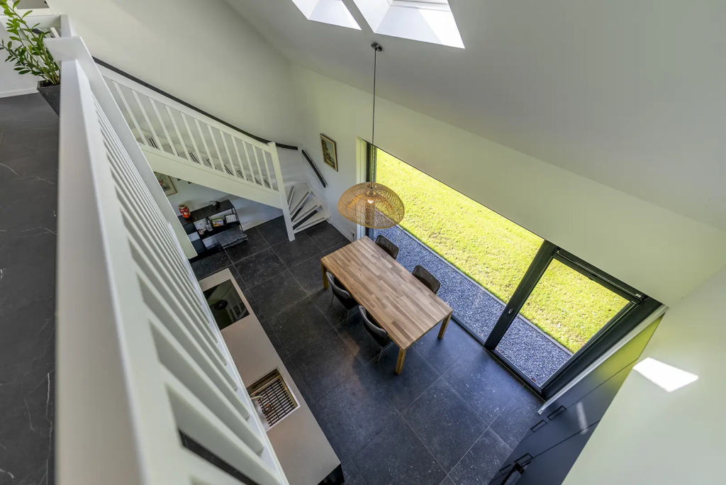 Eetkamer met vide en veel daglicht in moderne woning in Olst, ontworpen door Mensink Bouwbedrijf.